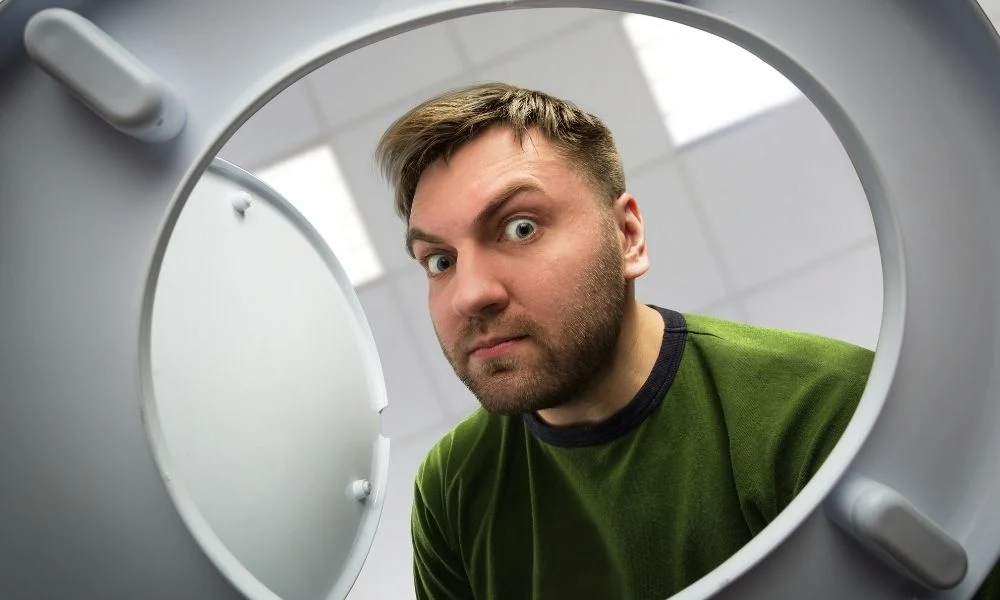 Man looking in a toilet bowl for signs of rats